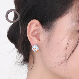 Détail d'un mannequin portant une boucle d'oreille boule avec des cristaux multicolores