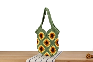 Close-up of handmade crochet sunflower tote bag showing green knit texture and floral patterns