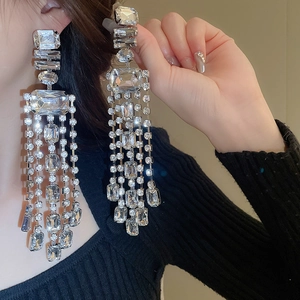 Macro shot of luxurious silver tassel earrings with geometric crystals and fringe