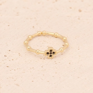 Detailed view of a gold cross ring with black zircon stones and beaded band texture