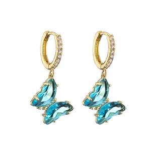 Golden crystal butterfly drop earrings with sparkling blue gemstones on white background