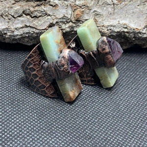 Close-up of vintage bronze ring with raw rectangular green jade and purple amethyst stones