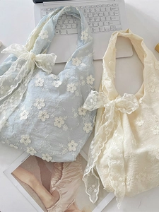 Floral embroidered tote bags in light blue and cream with large lace bow accents