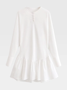 Detail of white long sleeve dress featuring buttoned neckline and ruffled hemline