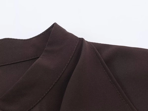 Dettaglio delle cuciture e della texture del collo a volant di questa camicia marrone