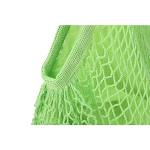 Macro detail of the green woven mesh handbag showing high-quality fiber texture and weave