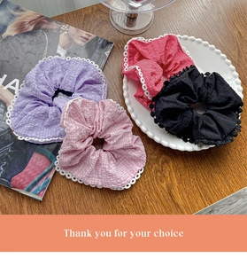 Detail of four colorful lace-edged hair scrunchies on a vintage plate