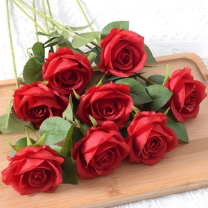 Realistic artificial red roses bouquet with green leaves on wooden tray for home decor