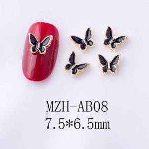 Macro shot of 7.5x6.5mm black enamel butterfly nail charms with gold metal edges