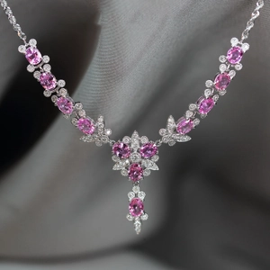 Luxury butterfly necklace with pink diamonds and white pavé crystals on grey velvet