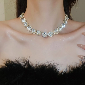 Close-up of a sparkling gold flower necklace with round cubic zirconia on a model's neck