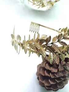 Macro detail of golden olive leaf crown with realistic textures and metal hair comb base