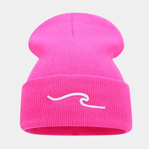 Detail of neon pink knit beanie featuring minimalist wave embroidery and fine texture
