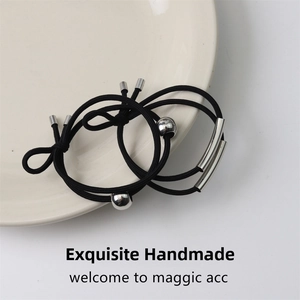 Detail of high-elastic black hair ties featuring polished silver beads and curved metal tubes
