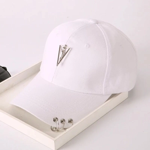 Close-up of a white baseball cap featuring a metal triangle and silver rings on the brim