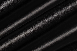 Nahaufnahme von schwarzem Leder mit Litschi-Struktur und Hochglanz-Finish am Kleid
