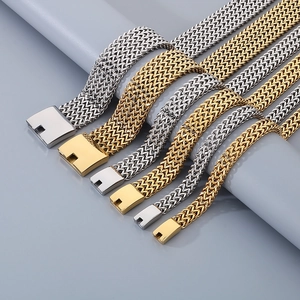 Flat lay of wide gold and silver woven titanium steel chains with square clasps