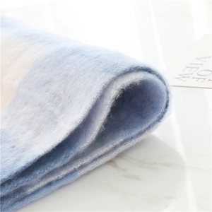 Macro detail of soft gradient blue mohair scarf with plush thick knit texture