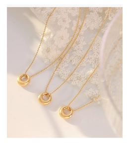 Three elegant 18K gold plated titanium steel necklaces with oval donut pendants