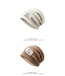 Detail shot of white and camel knitted beanies showing thick texture and woven labels
