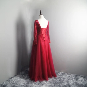 Detail of burgundy evening gown featuring lace, sequins, and a criss-cross open back design