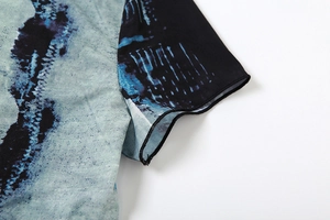 Close-up of sleeve cuff detail with abstract blue digital print and high-quality stitching