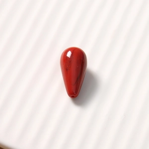 Macro detail of a red teardrop resin bead with agate texture for DIY jewelry making