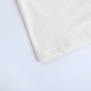 Close-up of fine plain weave fabric and detailed double-needle stitching on the white dress