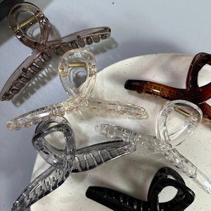 Top view of various 13cm glossy resin cross hair claws in clear, black, and amber colors