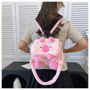 Detailed view of plush pink cartoon pig backpack with soft texture on a model back