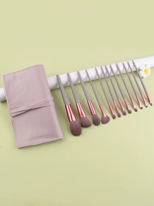Detailed set of 12 Morandi pink makeup brushes with a rolling leather pouch
