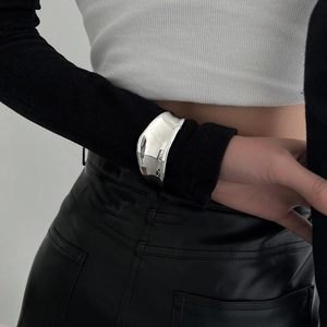 Irregular wide cuff bracelet in polished silver finish on model's wrist with modern style