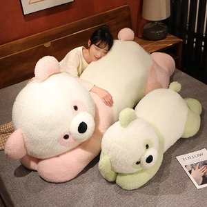 Grand coussin peluche panda couché en rose et vert sur un lit douillet et élégant