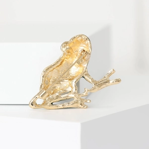 Back view of a gold frog brooch on a branch showing the pin and fastening structure