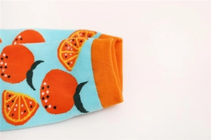 Détail de chaussettes en coton bleu avec motif orange et revers côtelé orange vif