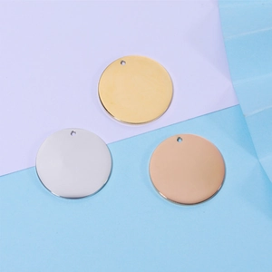 Detailed view of round 18k gold-plated stainless steel tags in gold, silver and rose gold
