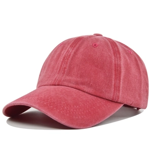 Detail of washed red cotton baseball cap showing vintage texture and curved brim
