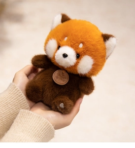 Close-up of a soft red panda plush toy with a brand tag and heart-shaped foot embroidery
