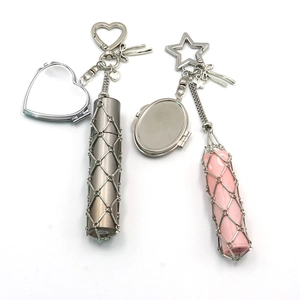Detail view of silver mesh lipstick holders with heart-shaped mirrors and keychains