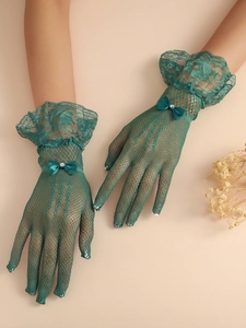 Detail of dark green lace fishnet bridal gloves with layered ruffles and pearl bow accent