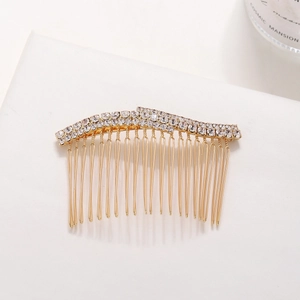 Elegant gold bridal hair comb with wavy double-row rhinestones on a white background