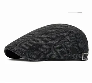 Close-up of the silver metal adjustable buckle on a dark gray herringbone flat cap