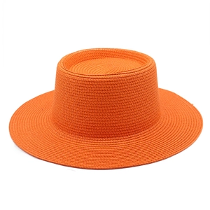 Wide brim orange straw sun hat with flat top for summer beach travel and sun protection