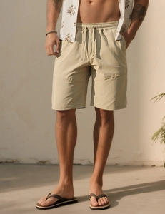 Detailed texture of khaki cotton shorts with elastic waistband and matching drawstring