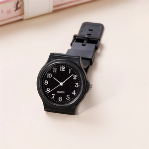 Close-up of minimalist black quartz watch with white Arabic numerals and plastic strap