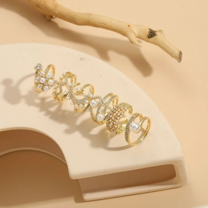 Macro detail of 6-piece gold ring set featuring pearls and sparkling zircon stones
