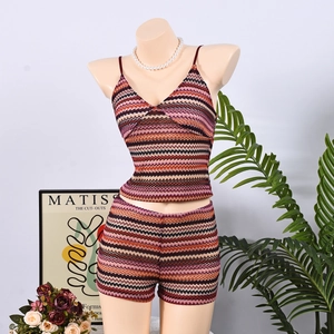Detail of knitted two-piece set featuring colorful zigzag patterns and crochet texture