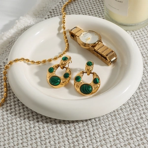 Detail of vintage gold stainless steel earrings featuring green malachite stone in a set