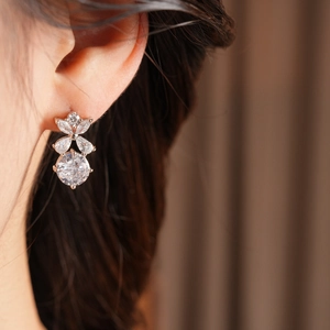Détail de la boucle d'oreille fleur évidée en or rose sertie de zircons cubiques brillants