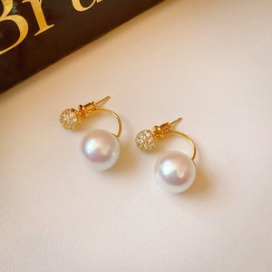 Detail of double-sided zircon stud earrings with large pearl and gold plating